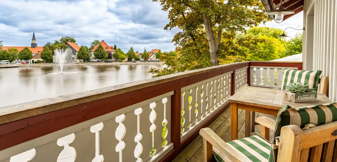 Landhaus Zu den Rothen Forellen in Ilsenburg – Balkon mit Seeblick und gemütlichen Sitzgelegenheiten | Wellnesshotel Harz