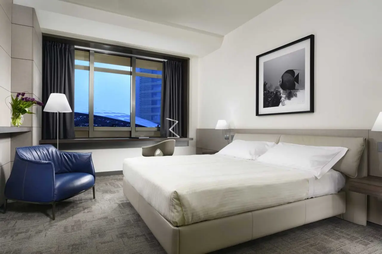 UNA Hotels San Vitale Bologna in Bologna – Komfortables Hotelzimmer mit Doppelbett und Sessel