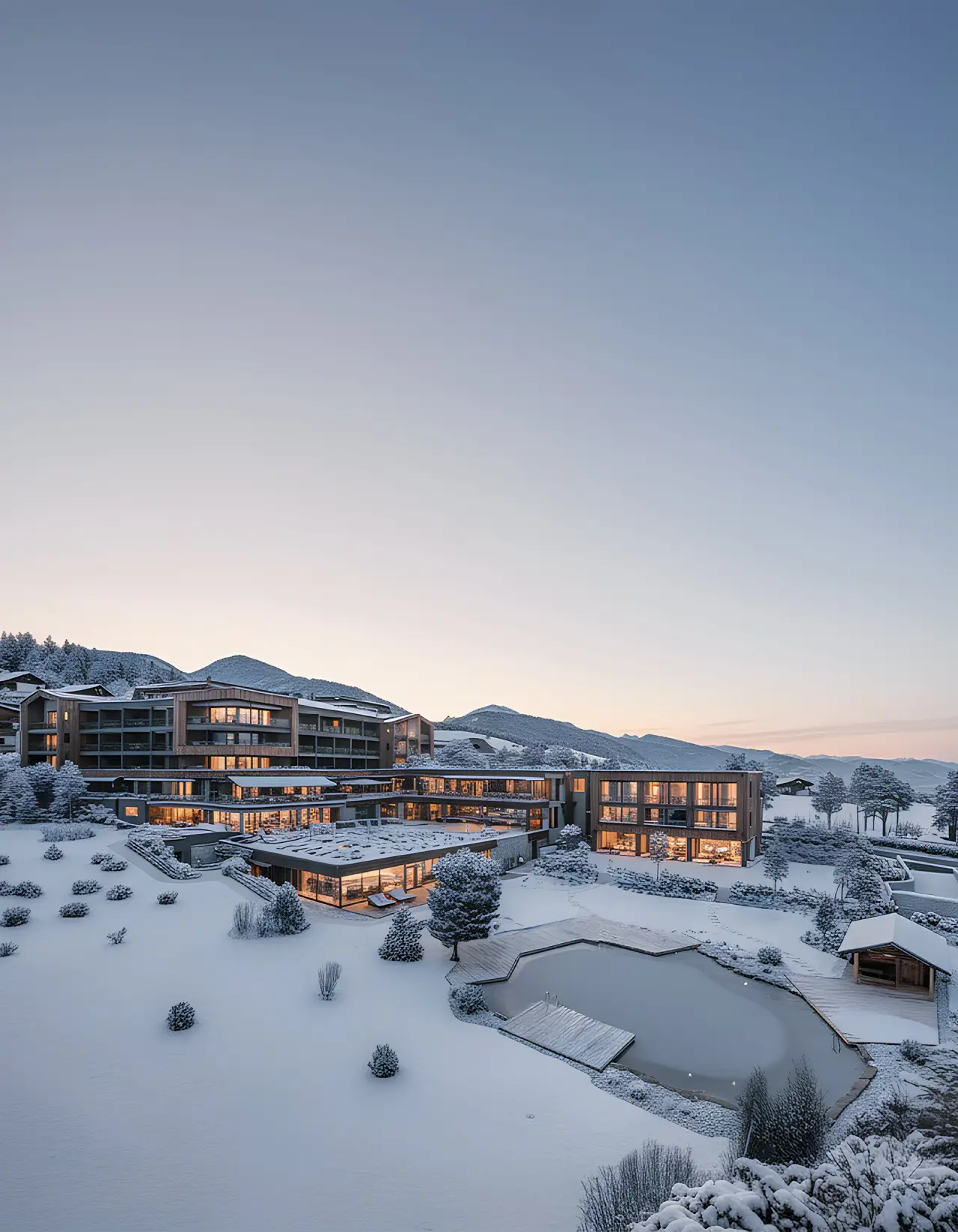 Sonnenberg in Terenten – Hotelanlage im Winter mit beleuchteten Gebäuden und Außenpool | Wellnesshotel Dolomiten