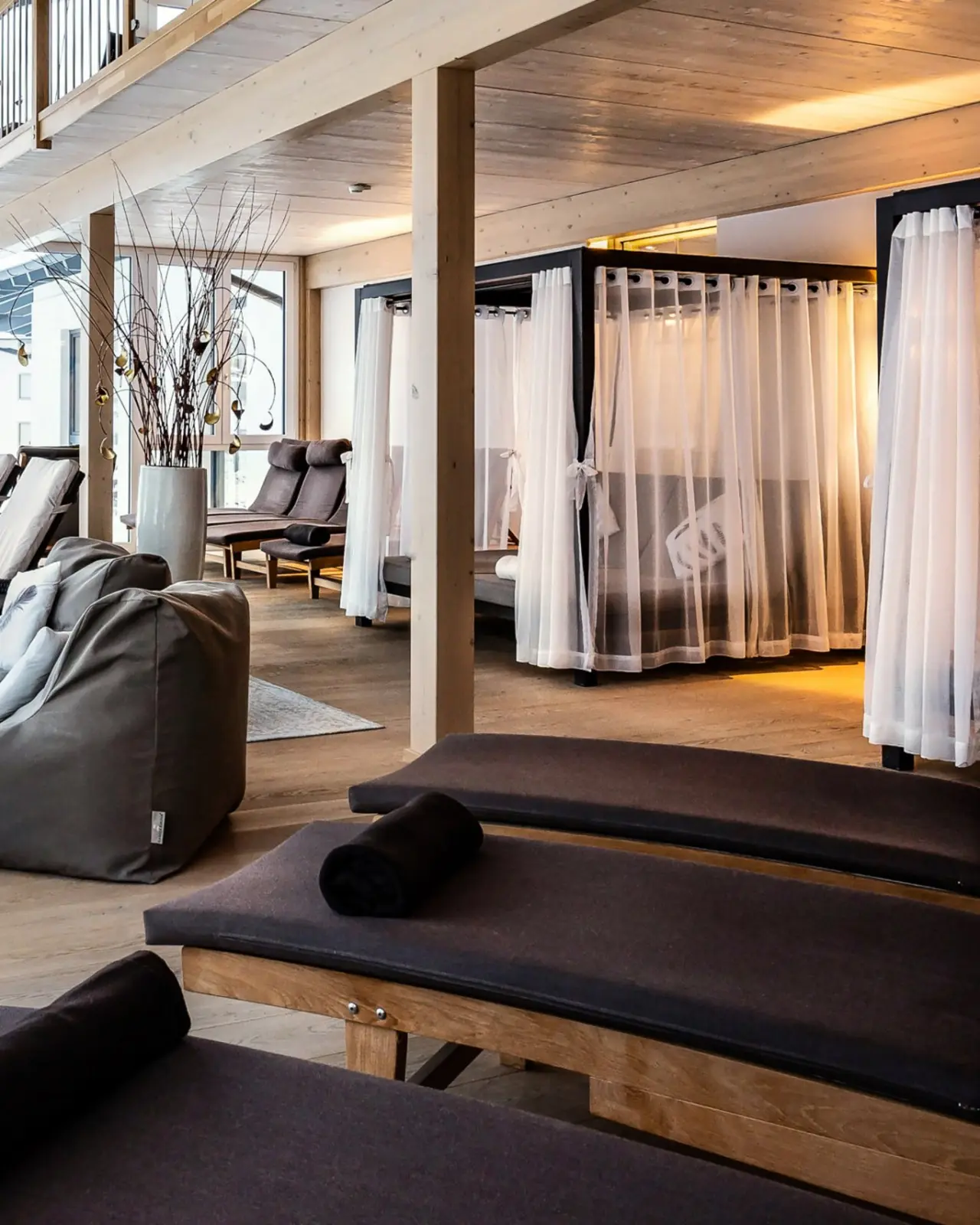 Panoramahotel Oberjoch in Bad Hindelang – Entspannungsbereich im Spa mit Daybeds und Holzelementen | Wellnesshotel Allgäu
