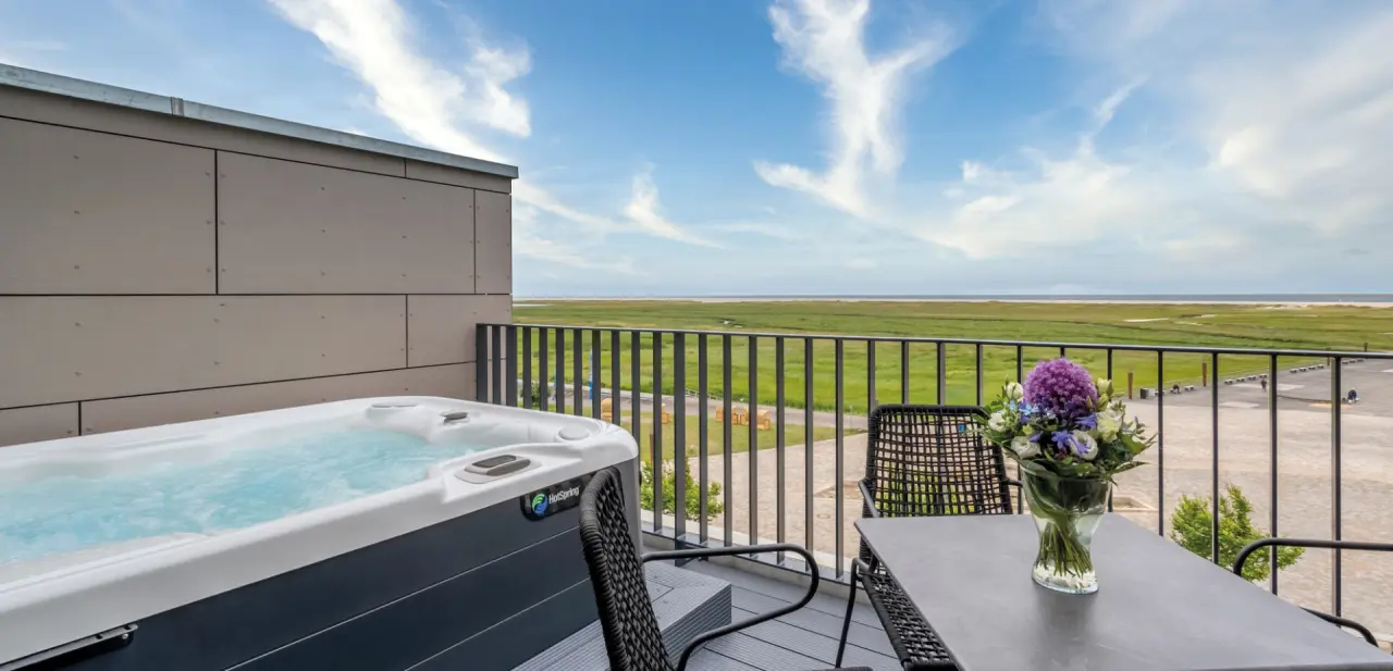 Ambassador Hotel & Spa in St. Peter-Ording – Balkon mit Whirlpool und Marschblick | Wellnesshotel Nordsee