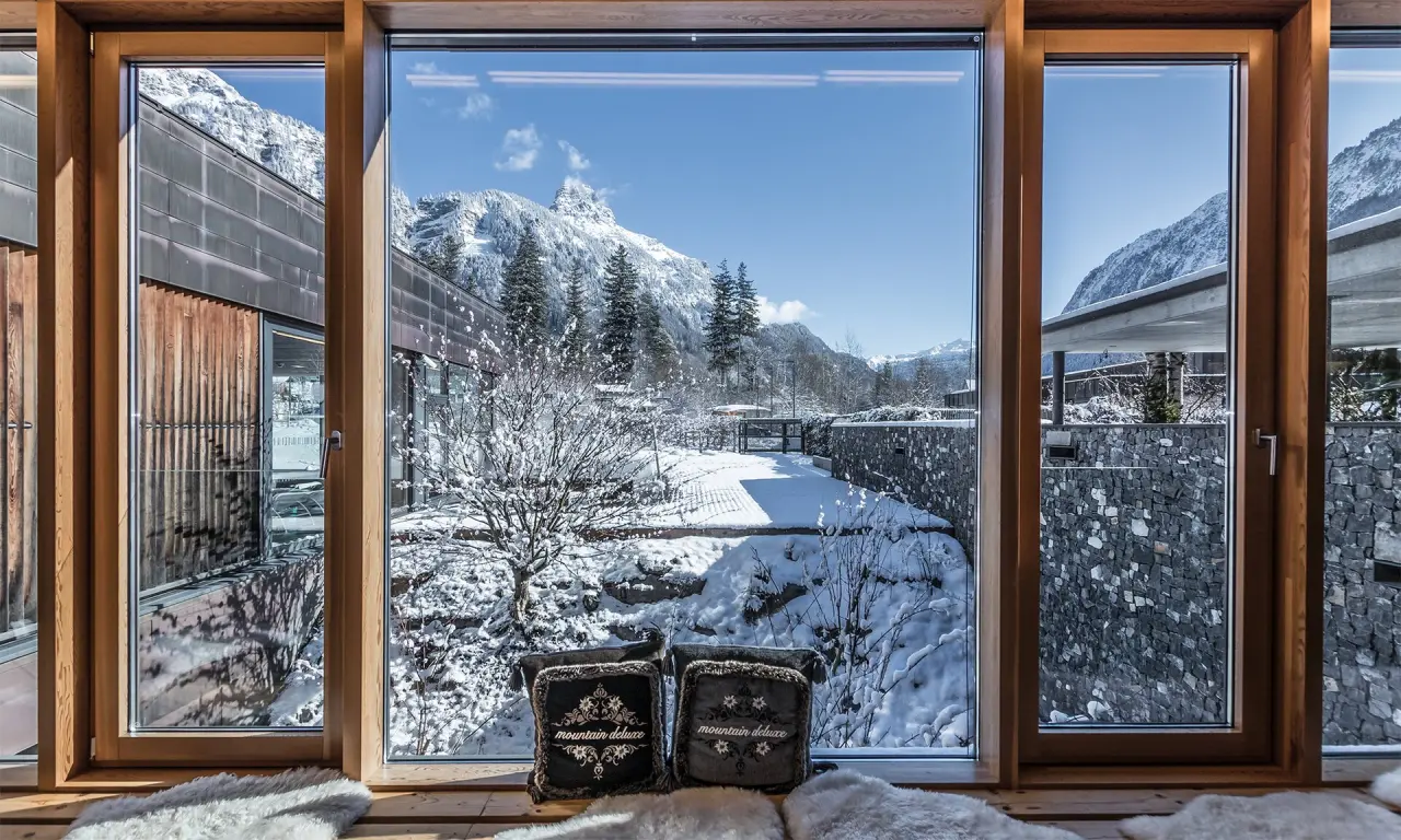 TRAUBE BRAZ Alpen.Spa.Golf.Hotel in Braz – Winterlandschaft durch Panoramafenster im Entspannungsbereich | Wellnesshotel Vorarlberg