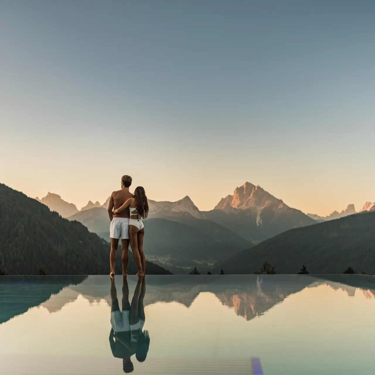 Hotel Alpen Tesitin in Toblach – Paar am Infinity-Pool mit Dolomiten-Panorama | Wellnesshotel Südtirol