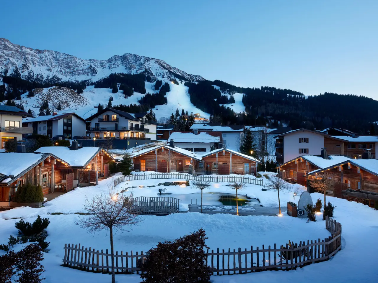 Alpin Chalets Oberjoch in Bad Hindelang – Winterliche Chalet-Anlage bei Abenddämmerung im Allgäu | Wellnesshotel Allgäu