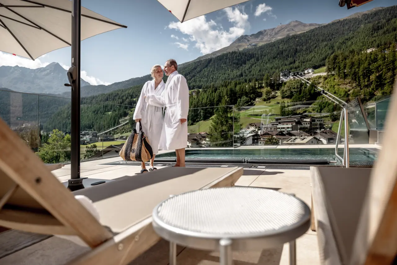Hotel Das Central in Hochgurgl – Paar im Bademantel am Infinity-Pool mit Alpenpanorama | Wellnesshotel Tirol
