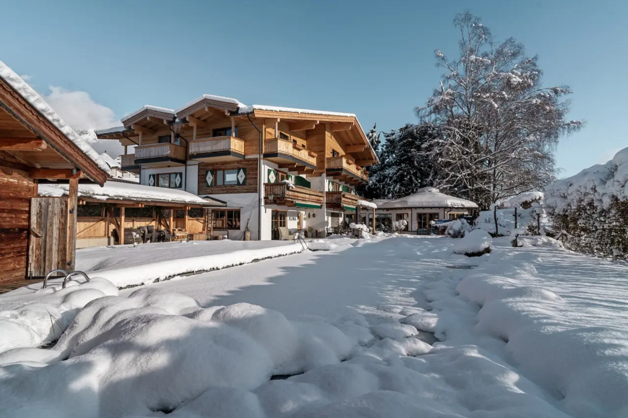 Hotel Hochfilzer in Ellmau – Hotelgebäude im Winter mit verschneiter Außenanlage | Wellnesshotel Tirol