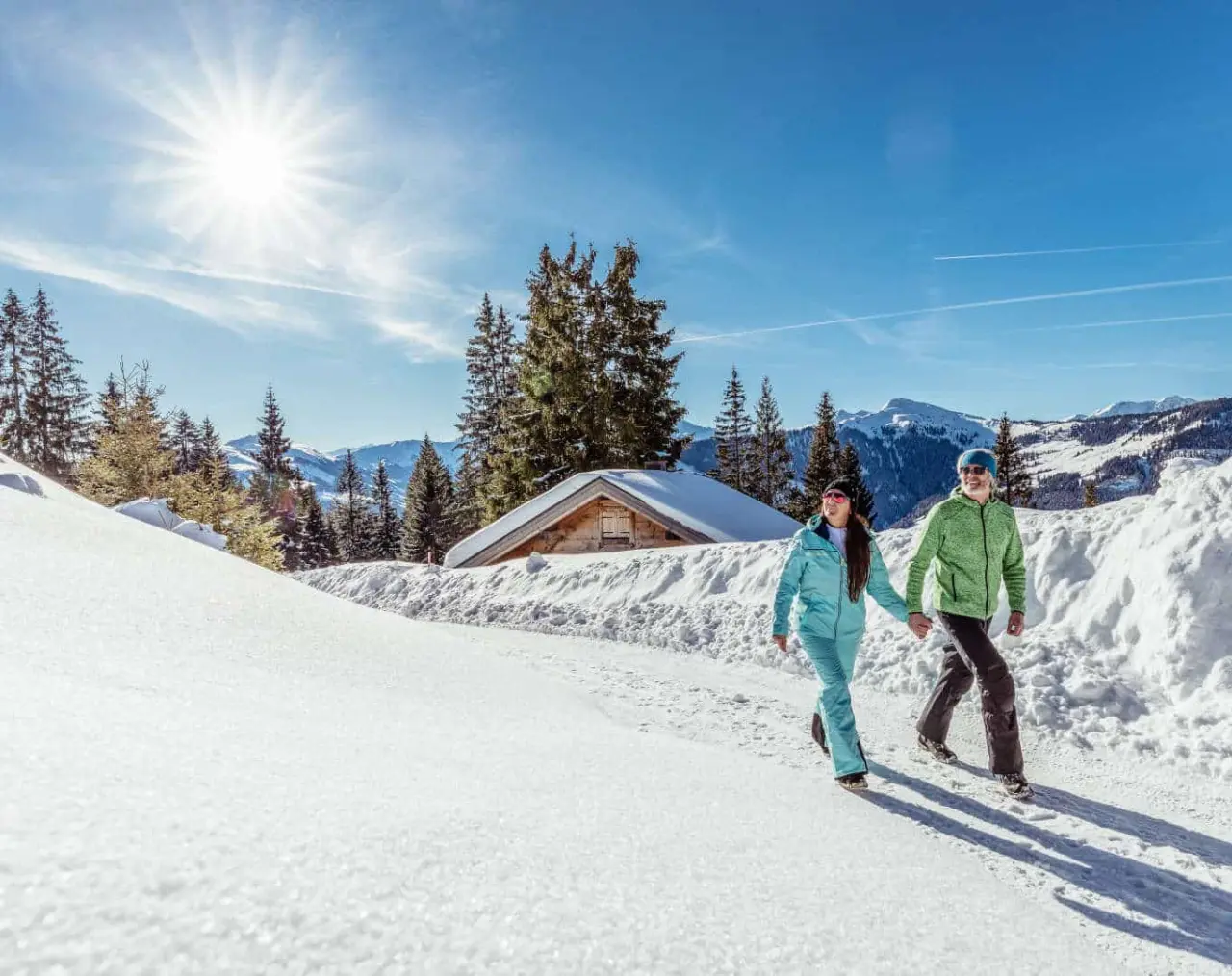 Alpbacherhof****s in Alpbach – Paar beim Winterwandern in der verschneiten Bergwelt | Wellnesshotel Tirol