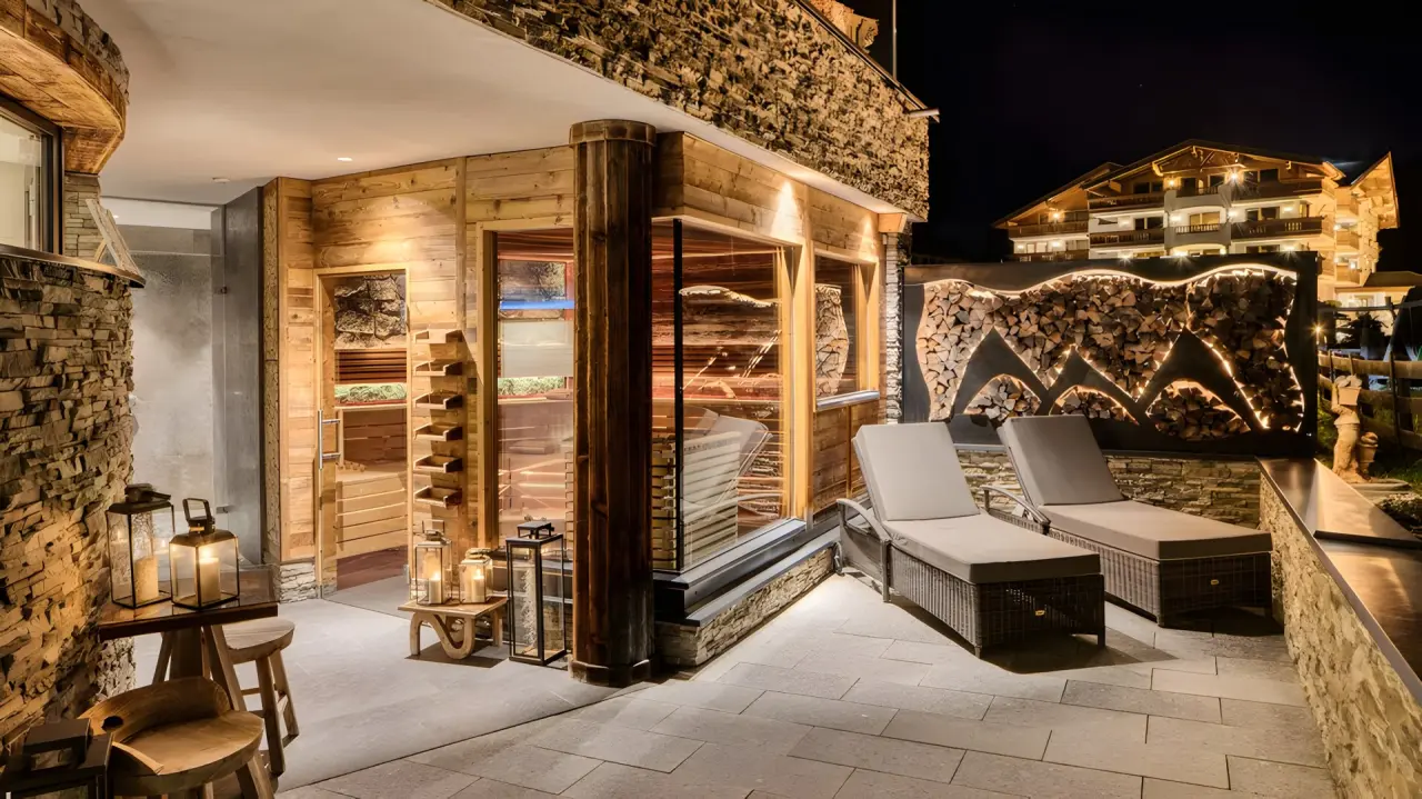 Activhotel Bergkönig in Neustift – Außen-Saunabereich mit Ruheliegen bei Nacht | Wellnesshotel Stubaital