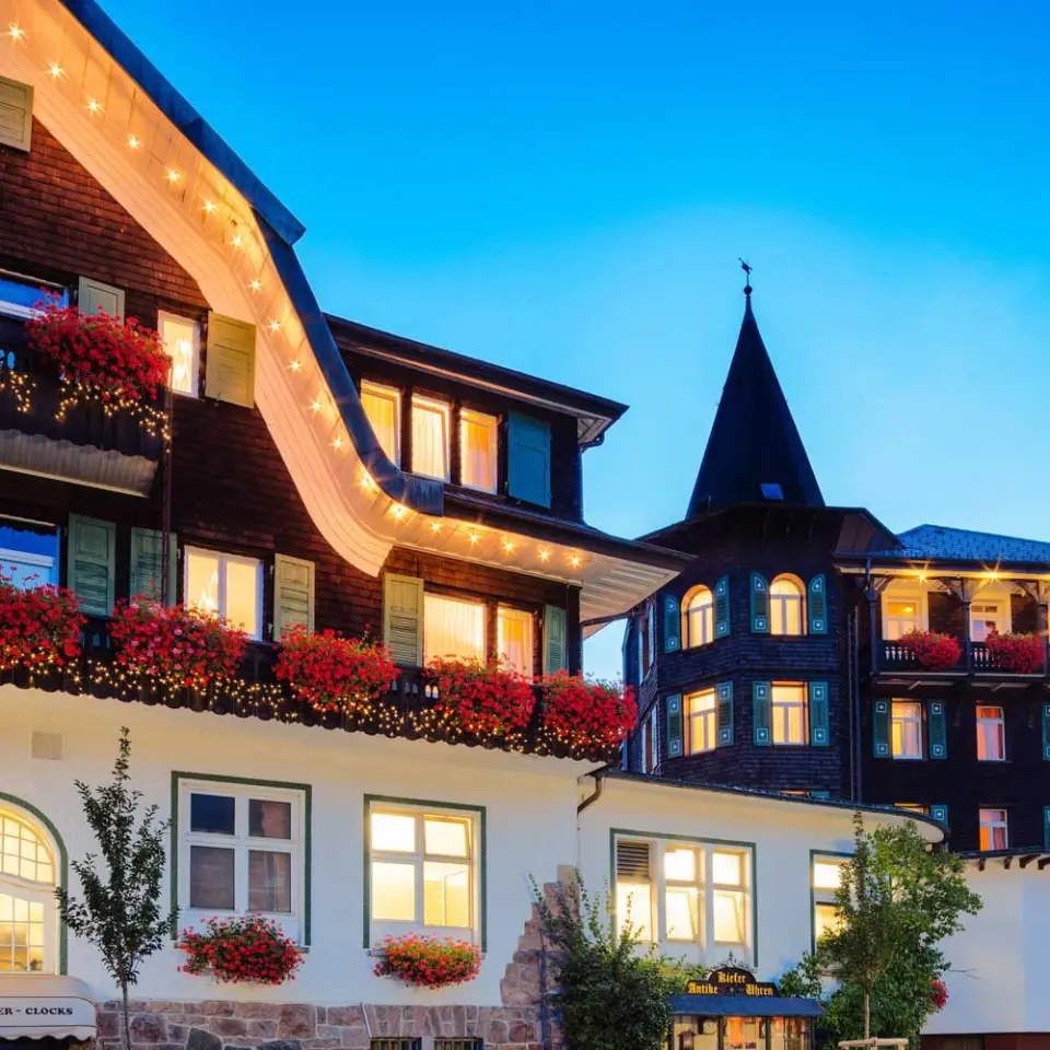 Treschers Schwarzwaldhotel in Titisee-Neustadt – Beleuchtete Fassade bei Abenddämmerung | Wellnesshotel Schwarzwald