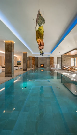 Klosterhof in Bayerisch Gmain – Stilvoller Innenpool mit Kunstinstallation und Kamin | Wellnesshotel Bayerische Alpen