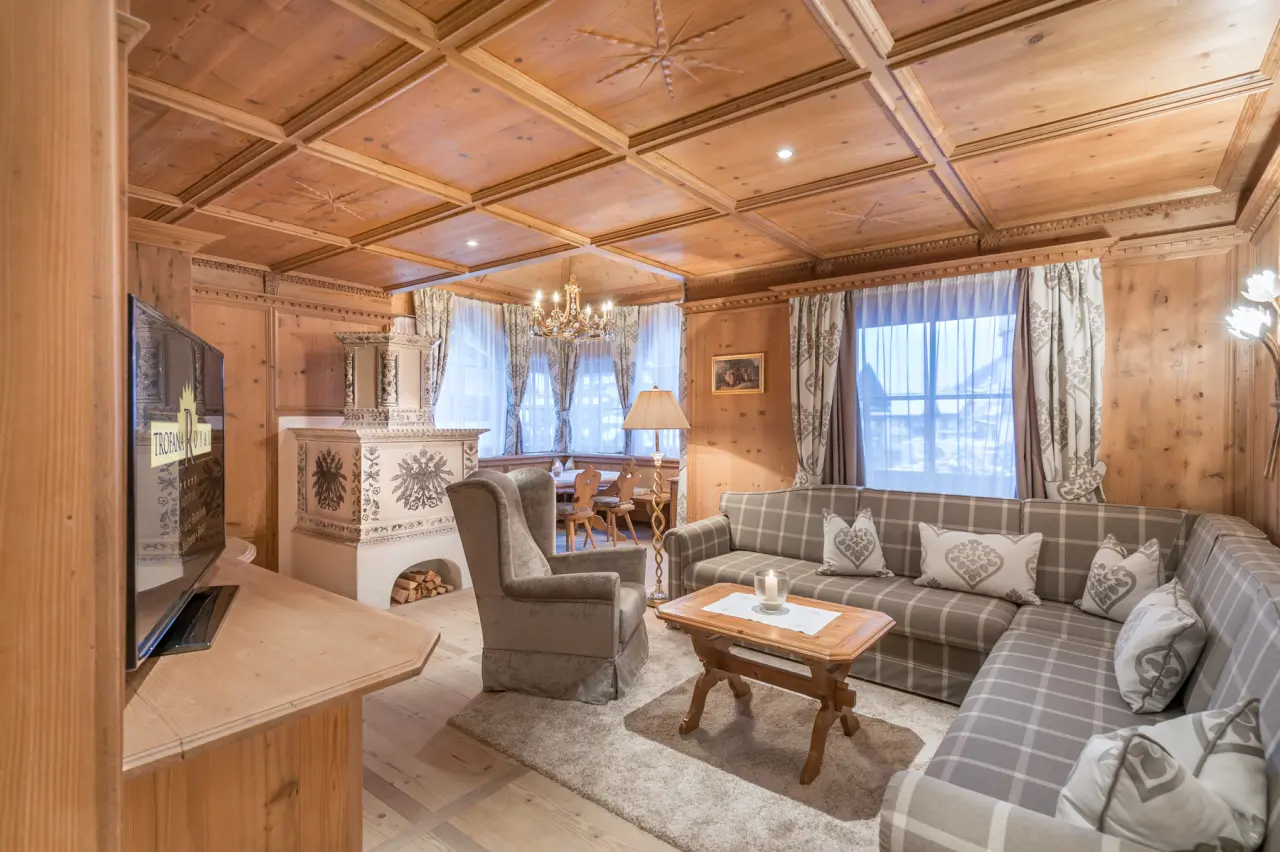 Hotel Trofana Royal in Ischgl – Traditioneller Wohnbereich mit Holzelementen und Kachelofen | Wellnesshotel Tirol