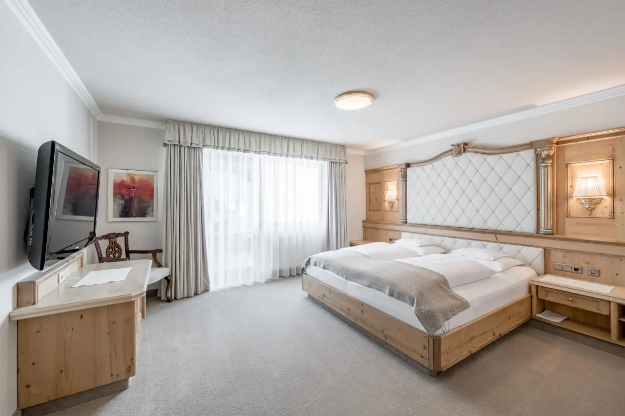 Hotel Trofana Royal in Ischgl – Helles Schlafzimmer mit Doppelbett und Holzakzenten | Wellnesshotel Tirol