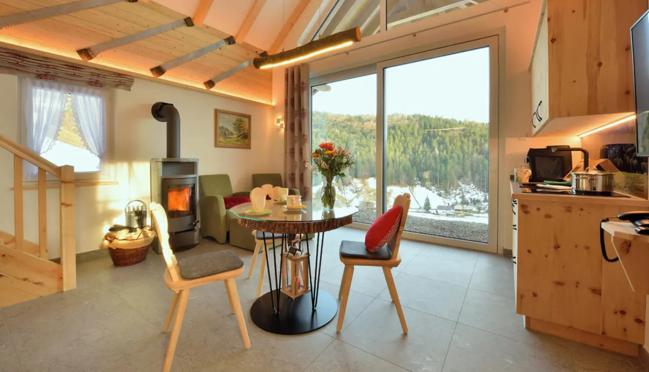 Hotel Rößle in Todtmoos – Gemütlicher Wohnbereich mit Kamin und Esstisch in einem Chalet | Wellnesshotel Schwarzwald