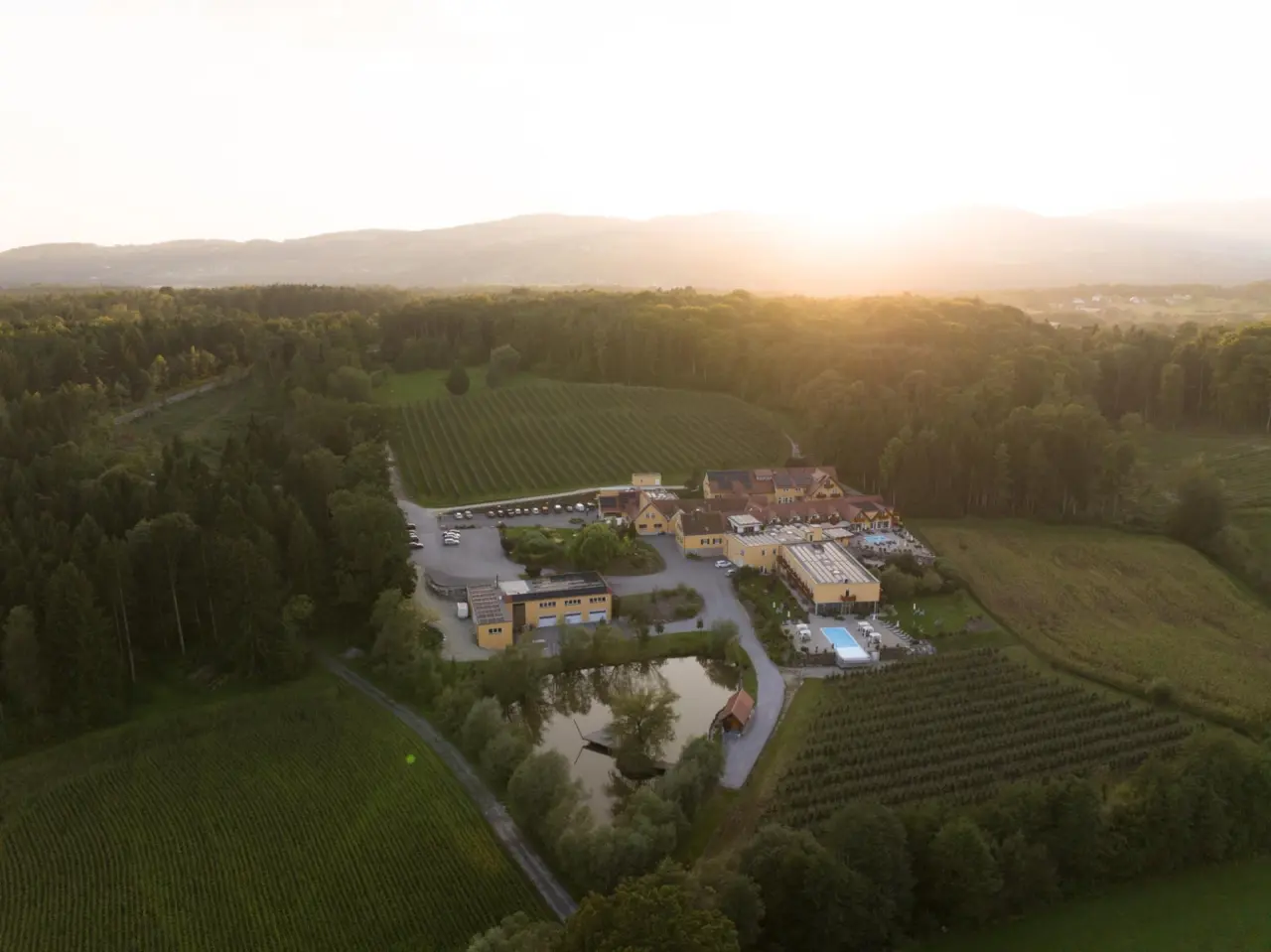 Natur Wellness Resort GRÜNE AU in Pöllau – Luftaufnahme des Resorts bei Sonnenuntergang | Wellnesshotel Steiermark