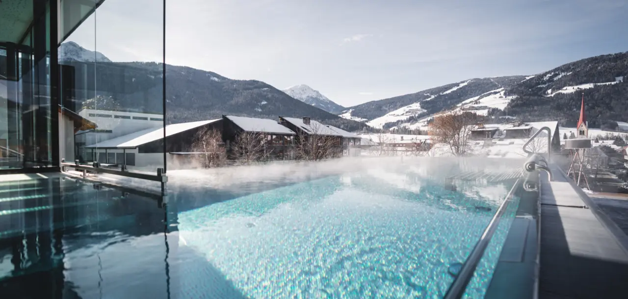 Hotel Fameli in Olang – Beheizter Infinity-Außenpool mit Bergblick im Winter | Wellnesshotel Dolomiten
