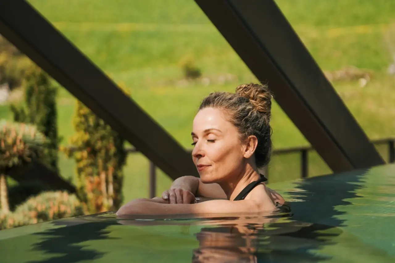 Hotel Quelle in St. Martin in Gsies – Frau entspannt im Infinity-Pool mit Bergblick | Wellnesshotel Südtirol