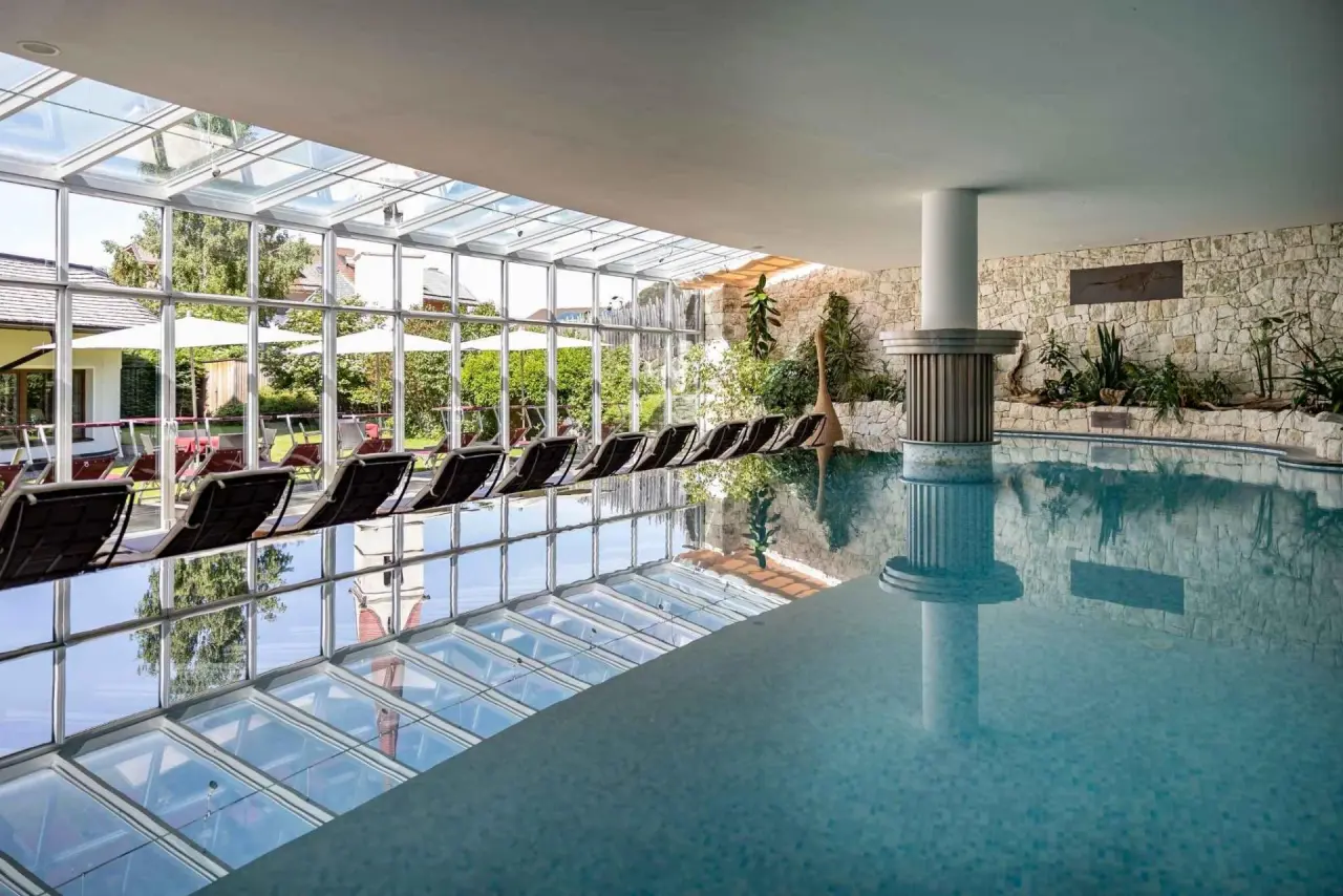 Artnatur Dolomites in Kastelruth – Heller Innenpool mit Glasfront und Liegen | Wellnesshotel Südtirol