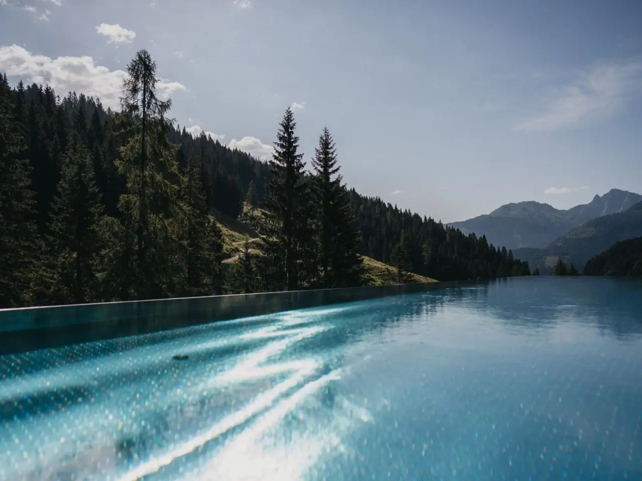 Almwellness-Resort Tuffbad in St.Lorenzen im Lesachtal – Infinity-Pool mit Blick auf die Bergwälder | Wellnesshotel Lesachtal