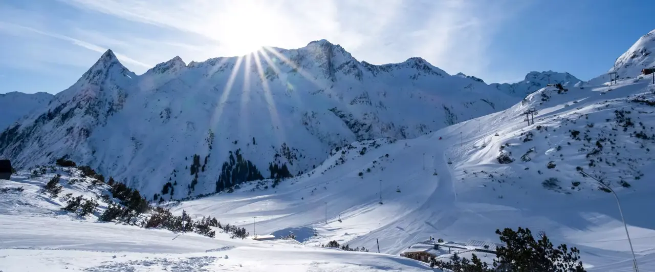 Alpenresort Fluchthorn in Galtür – Winterlandschaft mit verschneiten Bergen und Sonne | Wellnesshotel Paznaun