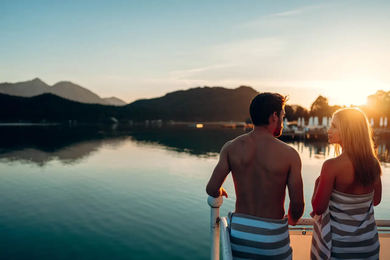 Wellnessresort Amerika-Holzer am See in St. Kanzian – Paar am Seeufer bei Sonnenuntergang | Wellnesshotel Kärnten