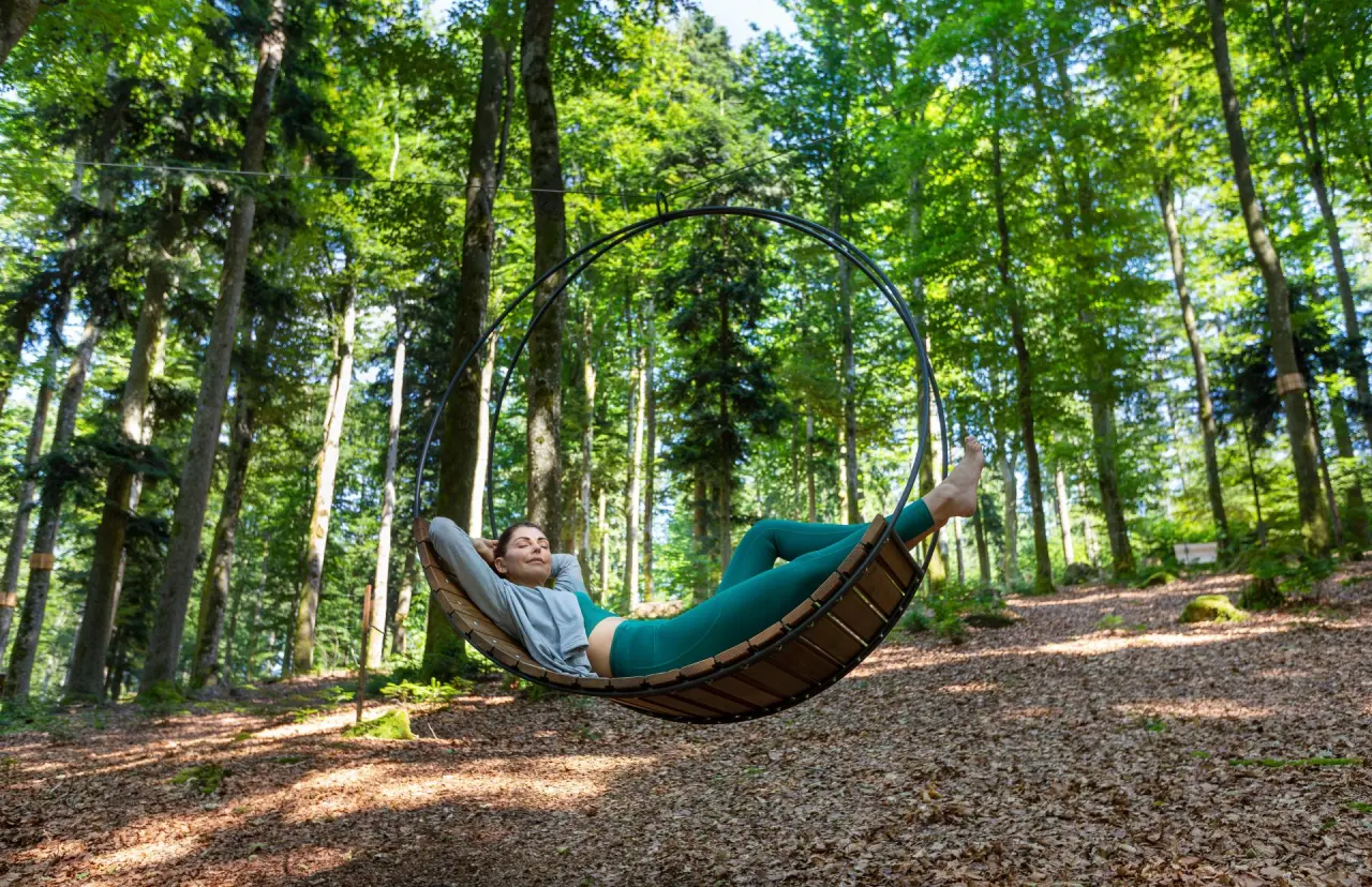 Wellness & Naturresort Reischlhof in Wegscheid – Frau entspannt in Hängesessel im Wald | Wellnesshotel Bayerischer Wald