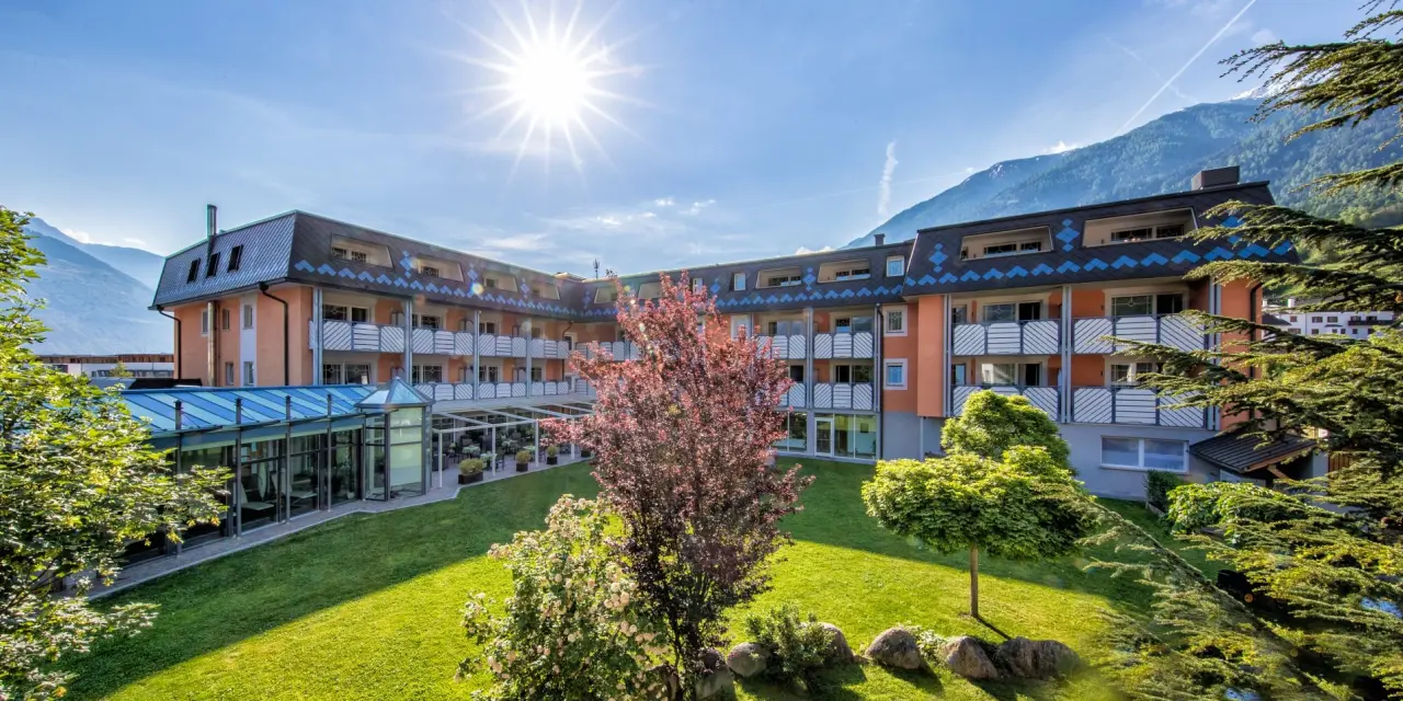 Aktiv- & Wellnesshotel Zentral in Mals – Hotelgebäude mit Garten und Bergpanorama | Wellnesshotel Vinschgau