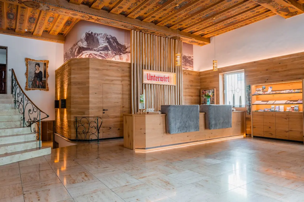 Hotel Unterwirt in Reit im Winkl – Empfangsbereich mit Holzdesign und Rezeption | Wellnesshotel Chiemgau