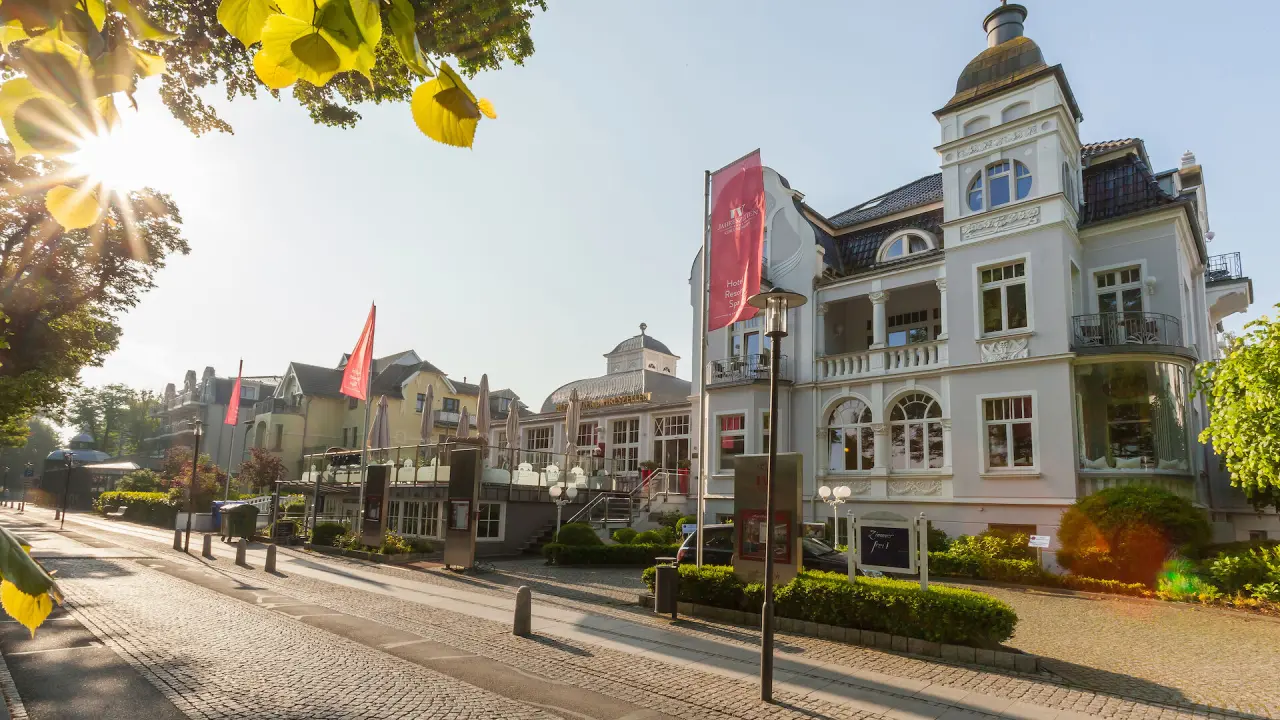 Hotel Vier Jahreszeiten Kühlungsborn in Kühlungsborn – Hotelansicht von der Straße mit Sonnenschein | Wellnesshotel Ostsee