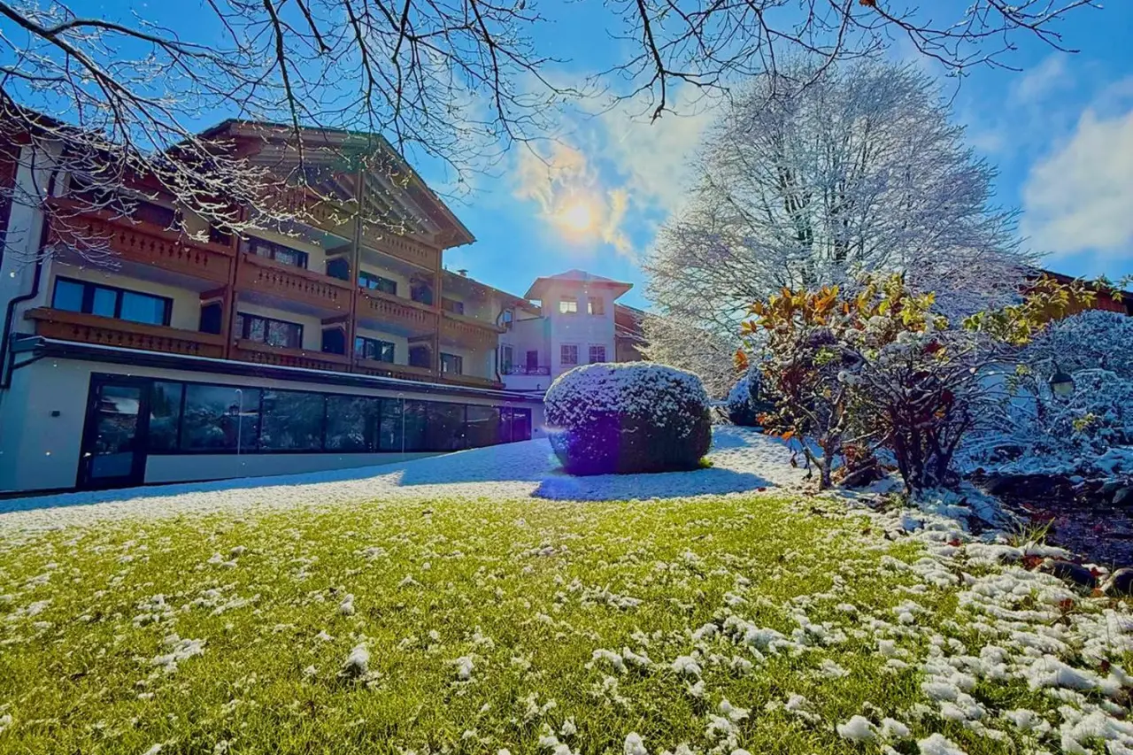 Hotel Rosenstock in Fischen im Allgäu – Hotelgebäude im Winter mit Schnee und Sonne | Wellnesshotel Allgäu