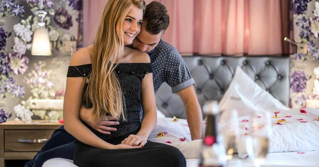 mein romantisches Hotel Garni Toalstock in Fiss – Romantisches Paar im Hotelzimmer mit Rosenblättern auf dem Bett | Wellnesshotel Tirol