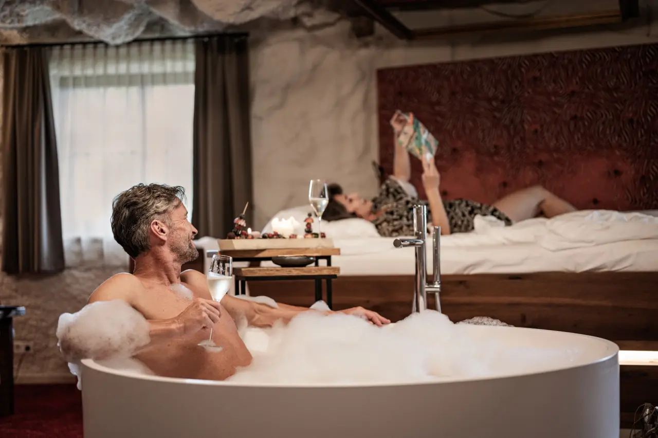 Genießerhotel Bergergut in Oberafiesl – Paar entspannt im luxuriösen Zimmer mit Badewanne | Wellnesshotel Oberösterreich