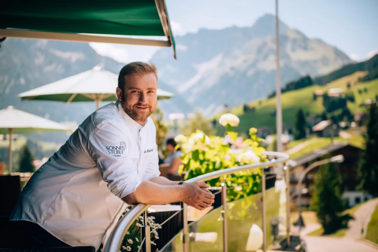 Hotel Birkenhöhe in Hirschegg – Küchenchef auf dem Balkon mit Bergblick | Wellnesshotel Kleinwalsertal