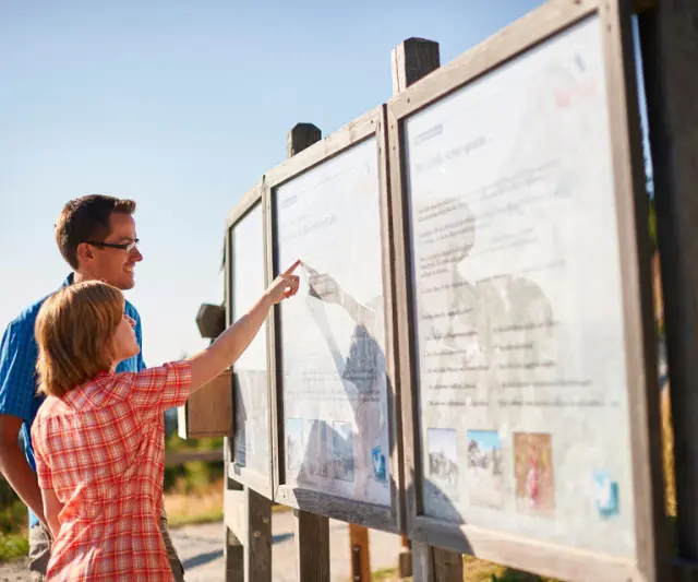 Wellnesshotel St. Gunther in Rinchnach – Gäste informieren sich an einer Wandertafel in der Natur | Wellnesshotel Bayerischer Wald