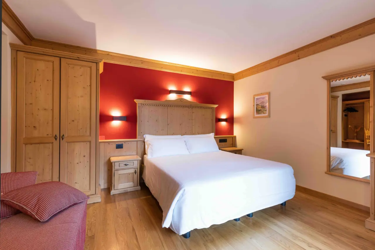 Hotel Medil in Campitello di Fassa – Helles Doppelzimmer mit roter Akzentwand | Wellnesshotel Dolomiten
