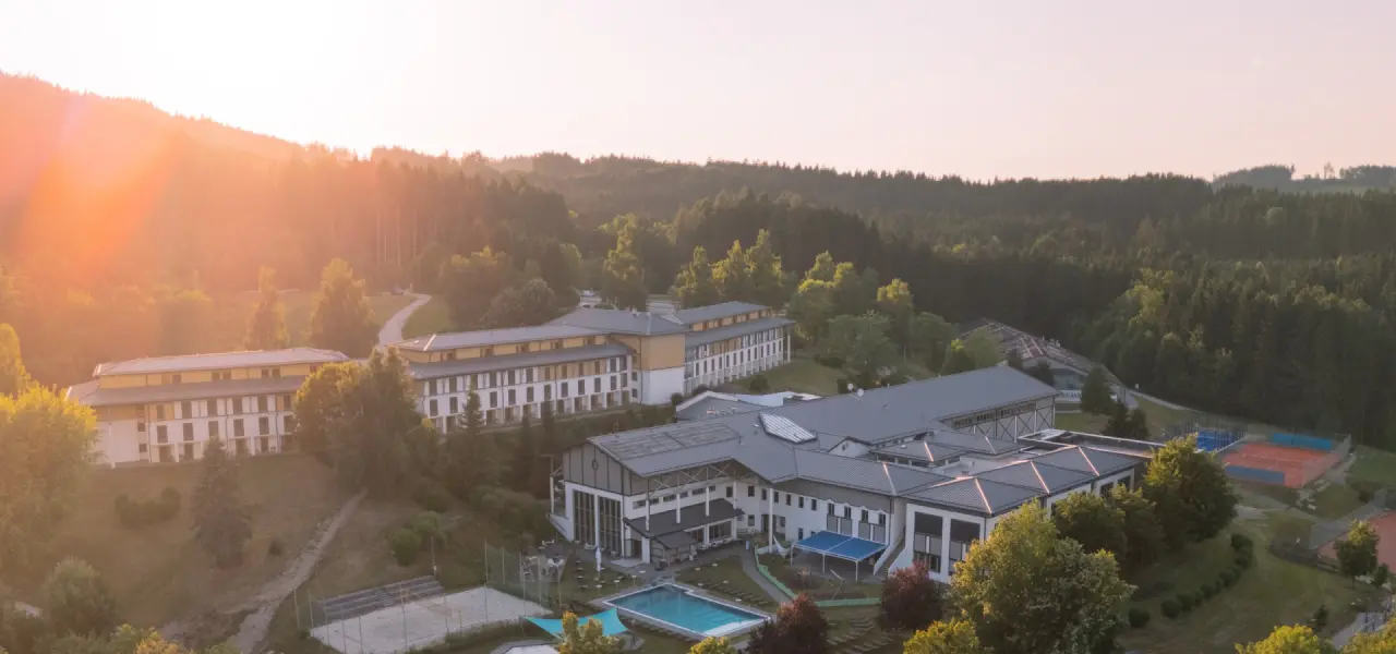 Aldiana Club Ampflwang in Ampflwang – Panoramablick auf das Hotel bei Sonnenuntergang | Wellnesshotel