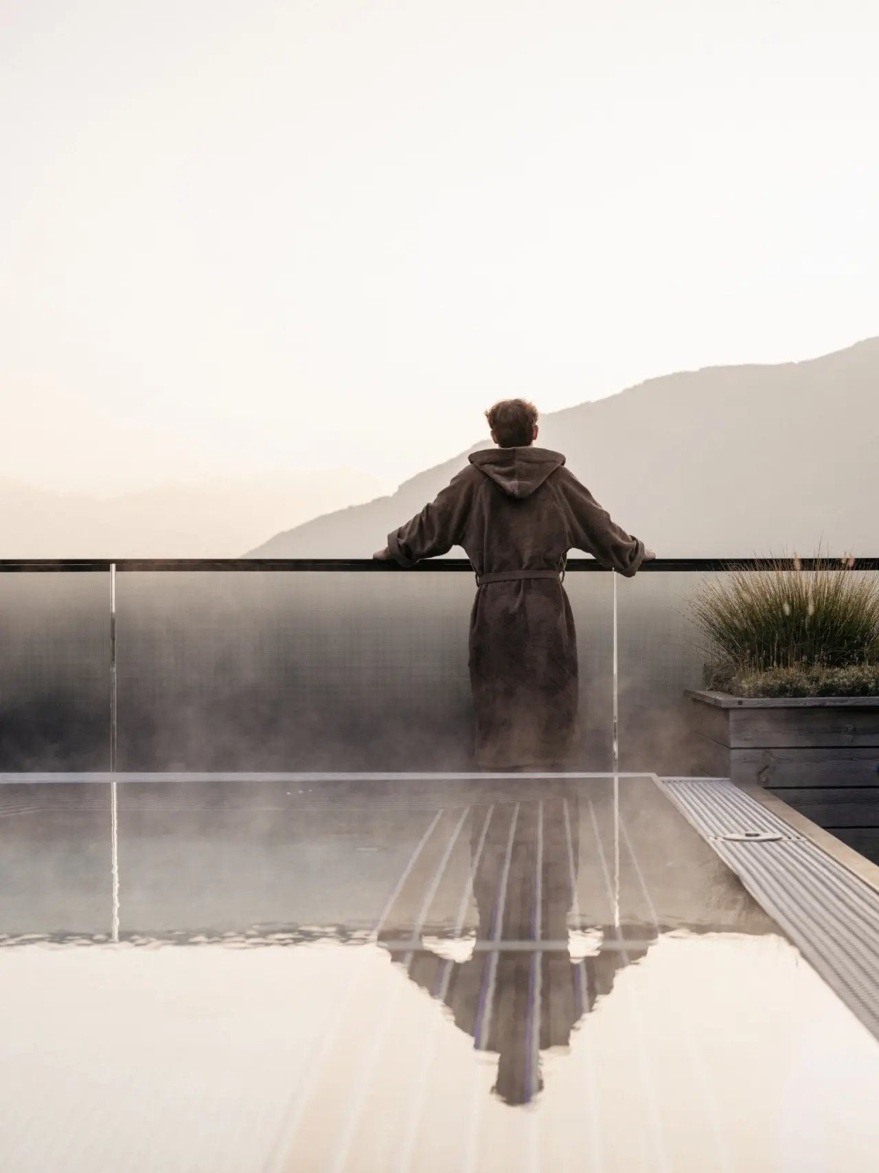 Lindenhof Pure Luxury & Spa DolceVita Resort in Meran – Gast im Bademantel am Infinity-Pool mit Bergblick | Wellnesshotel Südtirol