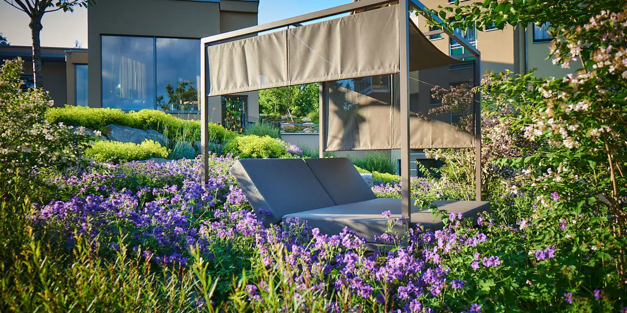 Hotel Reinerhof in St. Englmar – Gemütliches Daybed im blühenden Hotelgarten | Wellnesshotel Bayerischer Wald