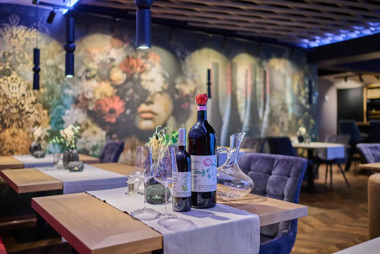 Hotel Reinerhof in St. Englmar – Stilvolles Restaurantambiente mit Weinflaschen und moderner Kunst | Wellnesshotel Bayerischer Wald
