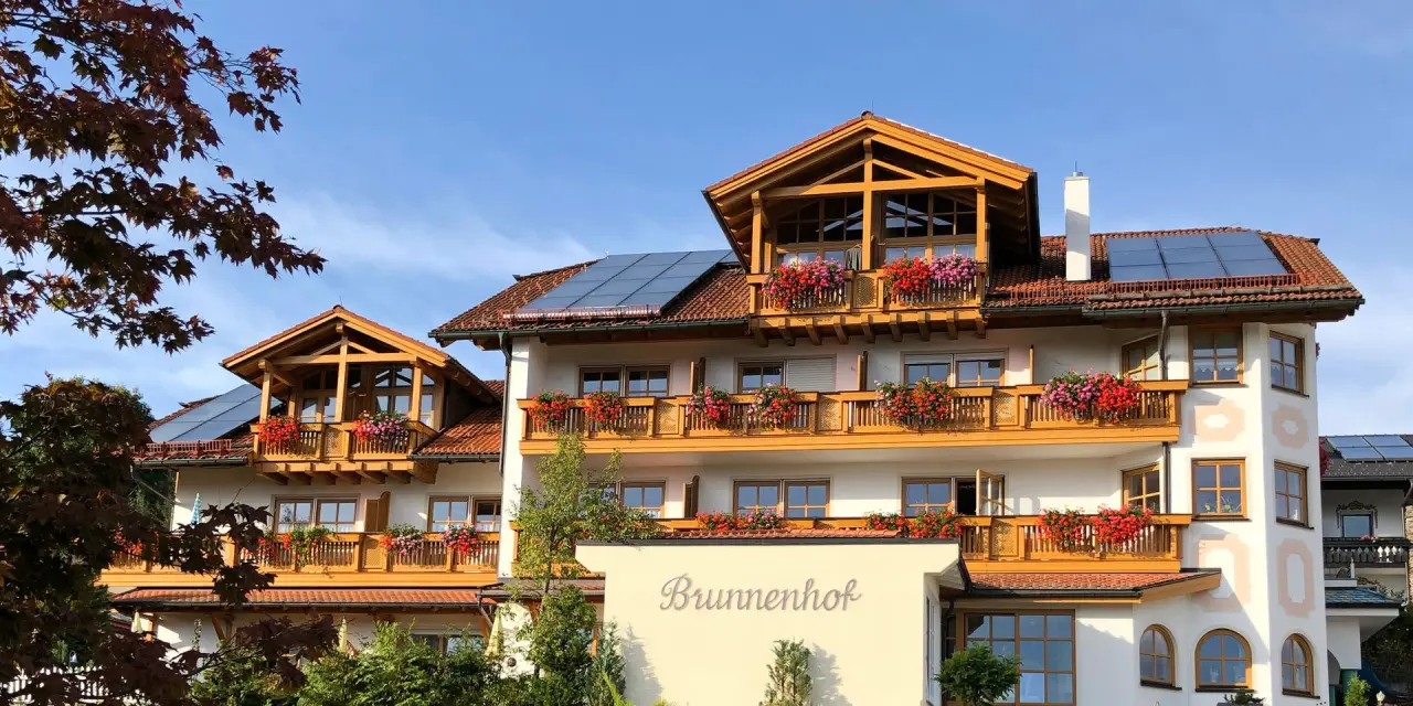 Hotel Brunnenhof in Bayerisch Eisenstein – Fassade mit blühenden Balkonen und Dach | Wellnesshotel Bayerischer Wald