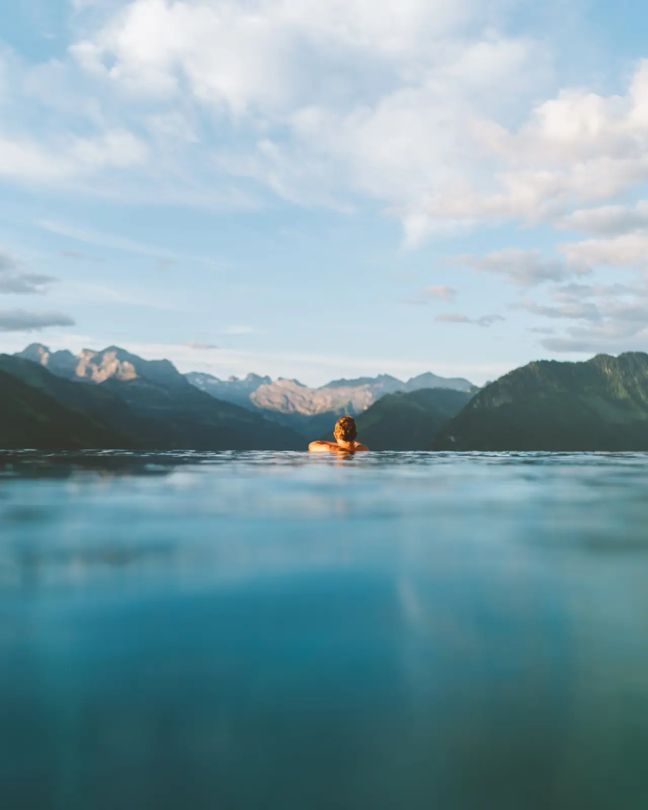 Hotel Villa Honegg in Obbürgen – Schwimmer im Wasser mit atemberaubendem Bergpanorama | Wellnesshotel Zentralschweiz
