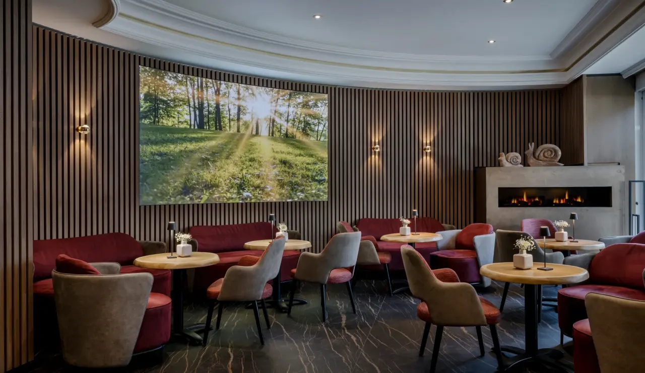 Hotel Lamm in Heimbuchenthal – Moderne Lounge mit Kamin, bequemen Sitzgelegenheiten und Naturmotiv | Wellnesshotel Spessart