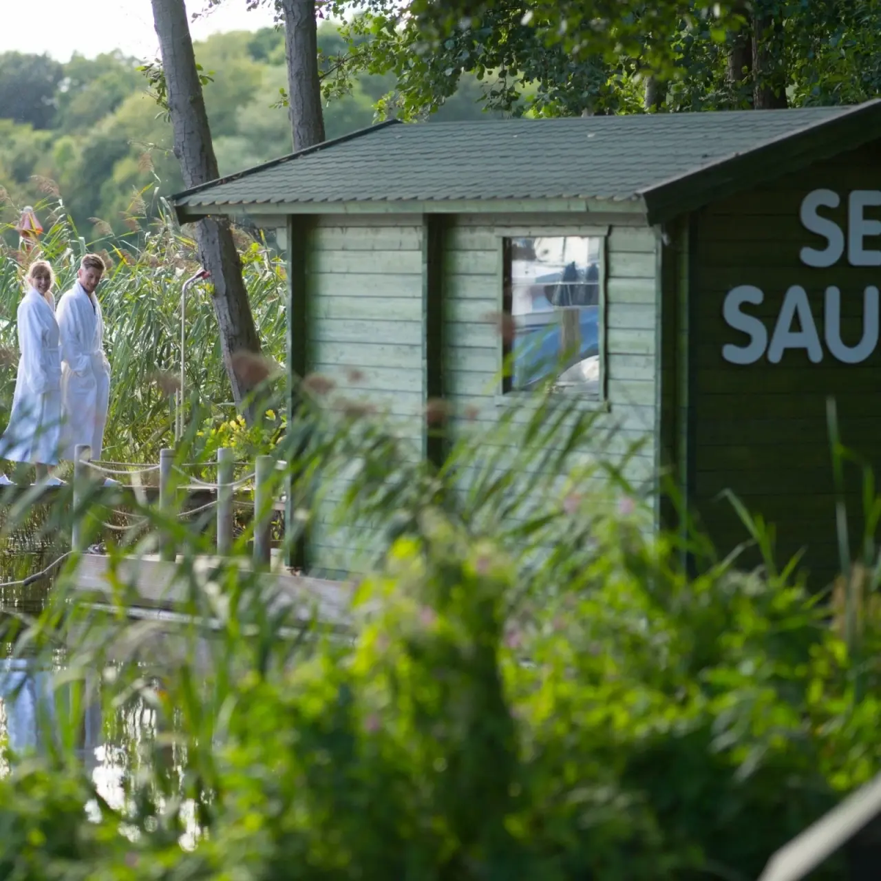 Seehotel Frankenhorst in Schwerin – Exklusive See-Sauna am Wasser mit Gästen in Bademänteln | Wellnesshotel Mecklenburg