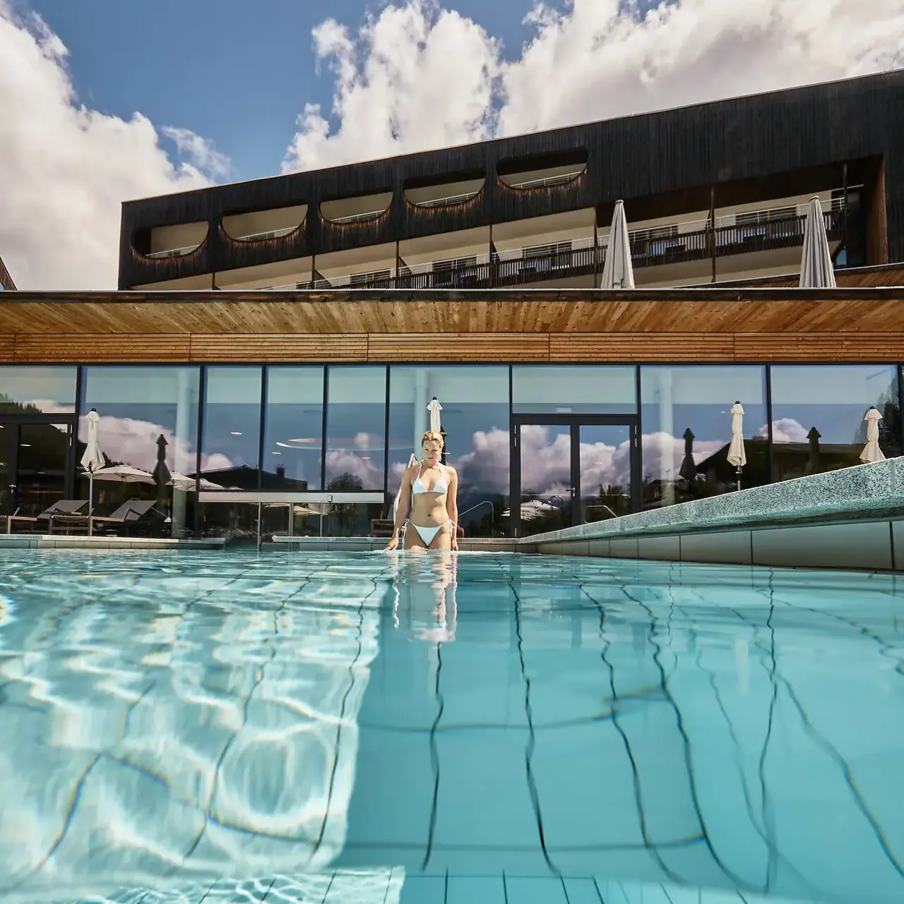 aja Werfenweng in Abtenau – Außenpool vor modernem Hotelgebäude | Wellnesshotel Salzburg