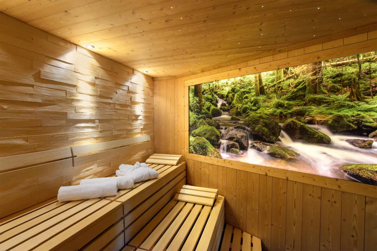 Hotel Grüner Wald****S in Freudenstadt – Moderne Sauna mit Waldmotiv und Handtüchern | Wellnesshotel Schwarzwald