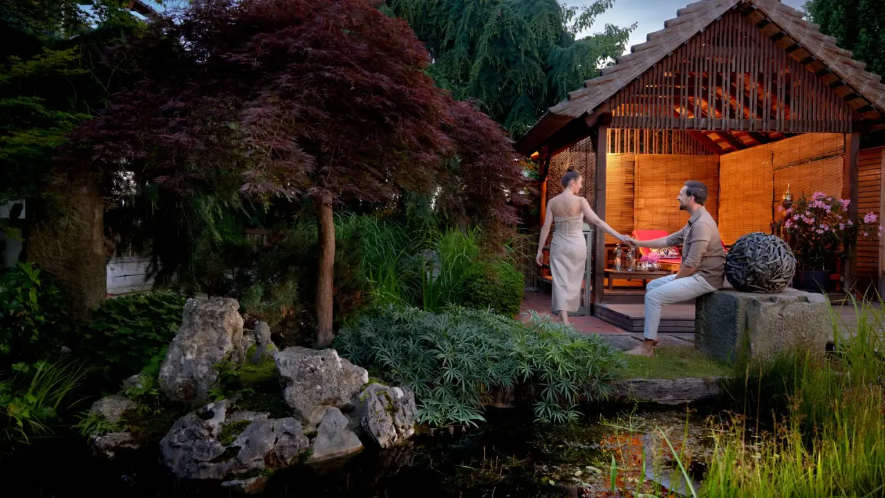 Ayurveda Resort Mandira in Bad Waltersdorf – Paar entspannt im Gartenpavillon am Teich | Wellnesshotel Steiermark