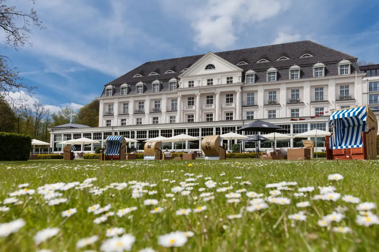 A-Rosa Grand Spa Travemünde in Lübeck-Travemünde – Hotelgebäude mit Strandkörben und Blumenwiese | Wellnesshotel Ostsee