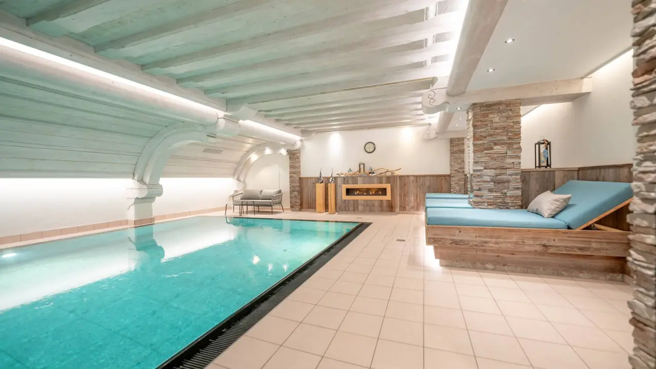 Dein Engel in Oberstaufen – Stilvoller Innenpool mit Holzdecke und Ruheliegen | Wellnesshotel Allgäu