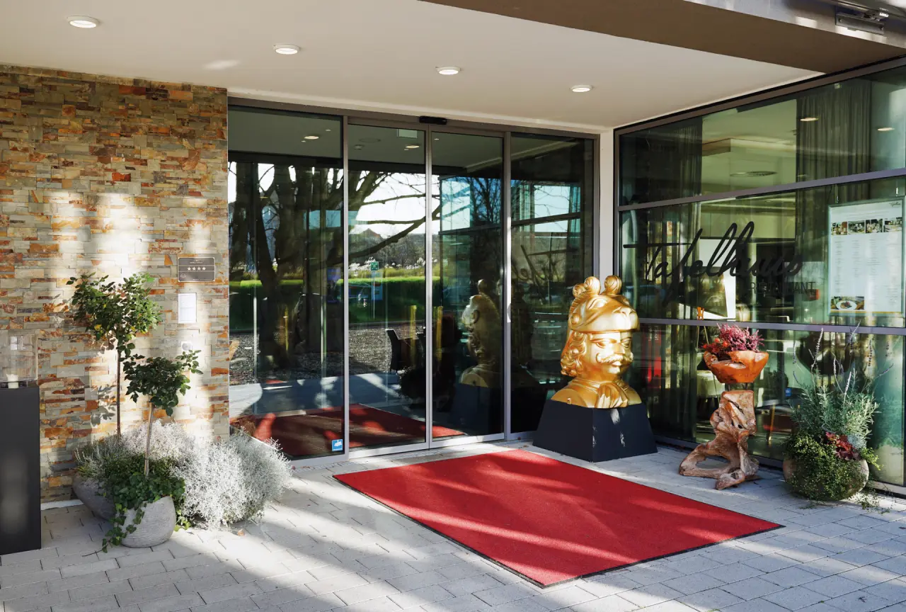 WONNEMAR Resort-Hotel Wismar in Wismar – Hoteleingang mit rotem Teppich und Steinmauer | Wellnesshotel Mecklenburg-Vorpommern