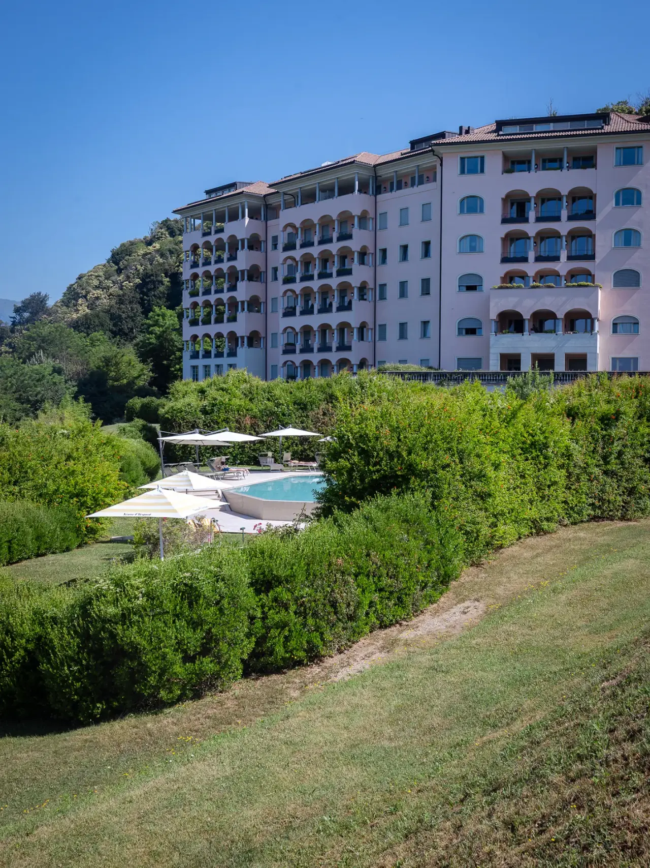 Resort Collina d'oro in Agra – Gesamtansicht des Hotels mit Außenpool und grüner Landschaft | Wellnesshotel Tessin