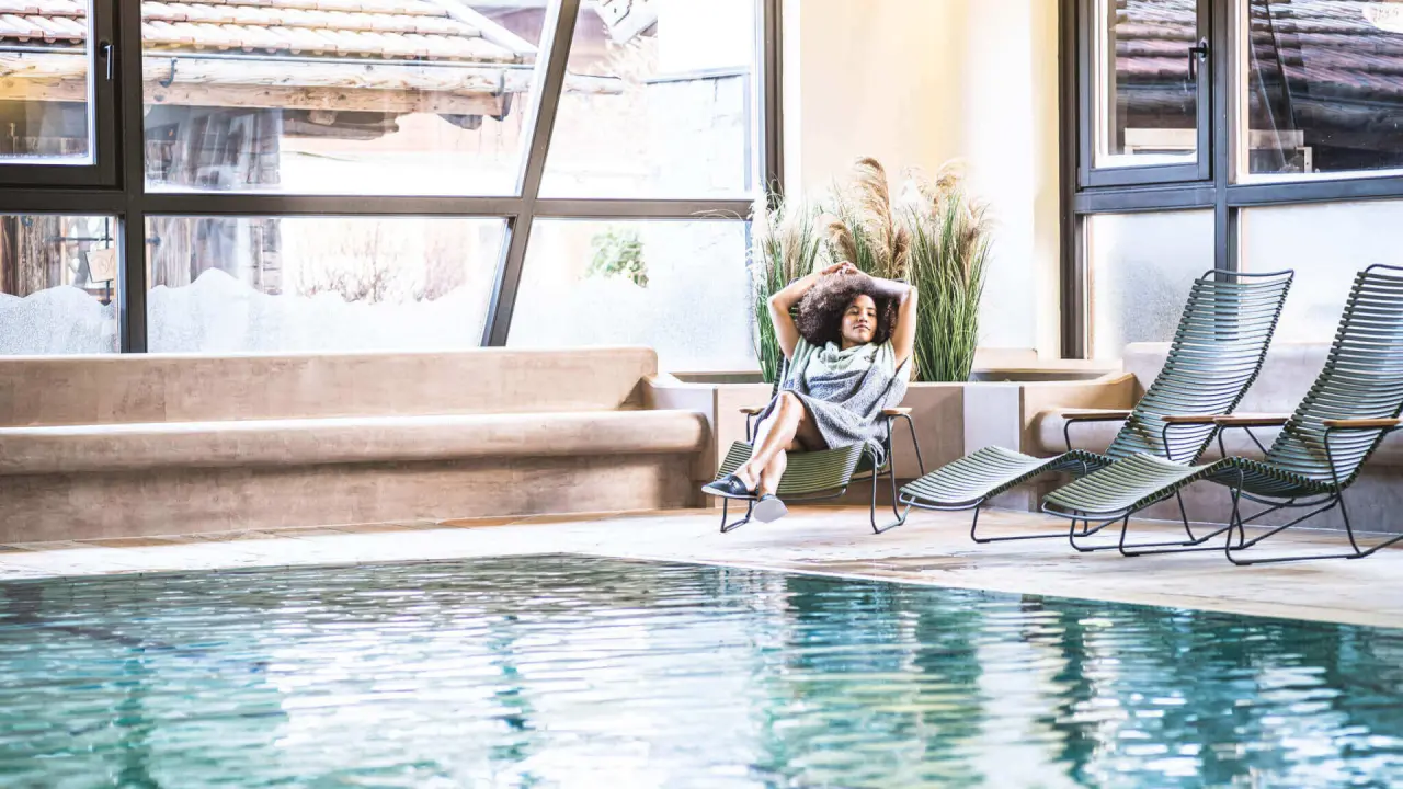 Das Falkenstein Kaprun in Kaprun – Entspannungsbereich am Innenpool mit Bergblick | Wellnesshotel Kaprun